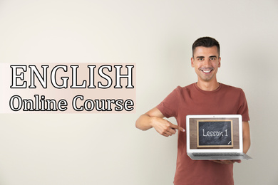 Young teacher with laptop on light background. Online English course