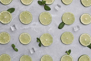Photo of Flat lay composition with slices of fresh juicy limes on marble table