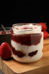 Tasty yoghurt with jam and strawberries on wooden board, closeup