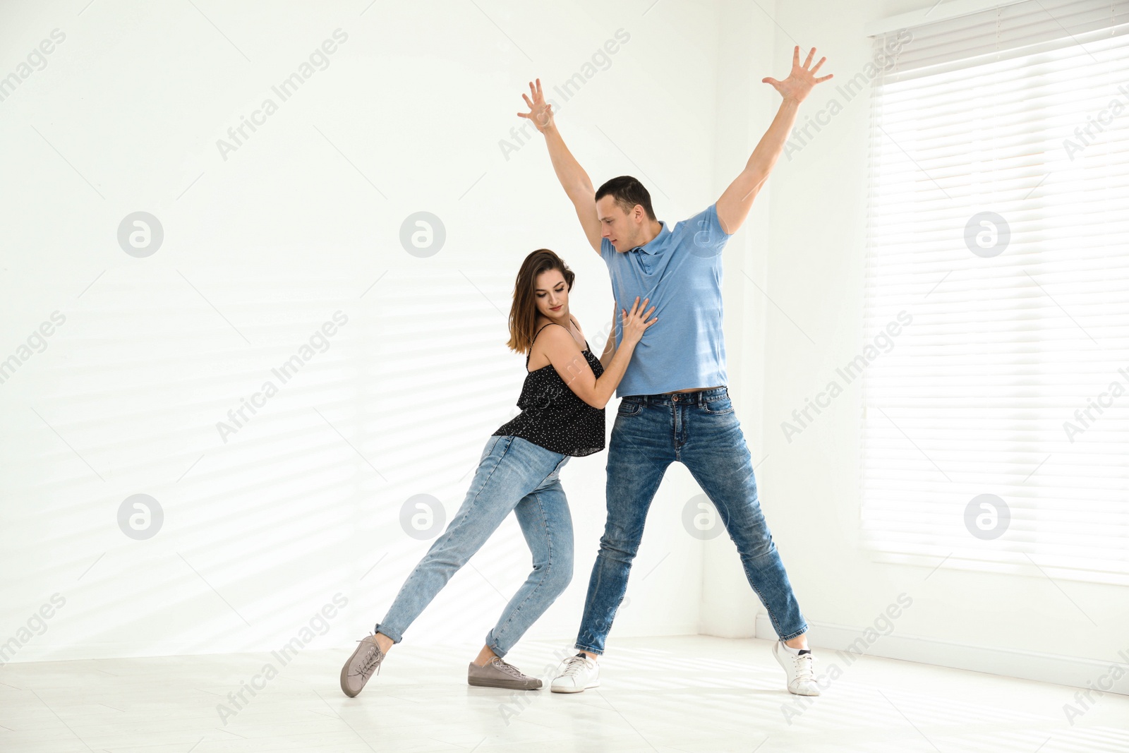 Photo of Beautiful young couple dancing in empty studio