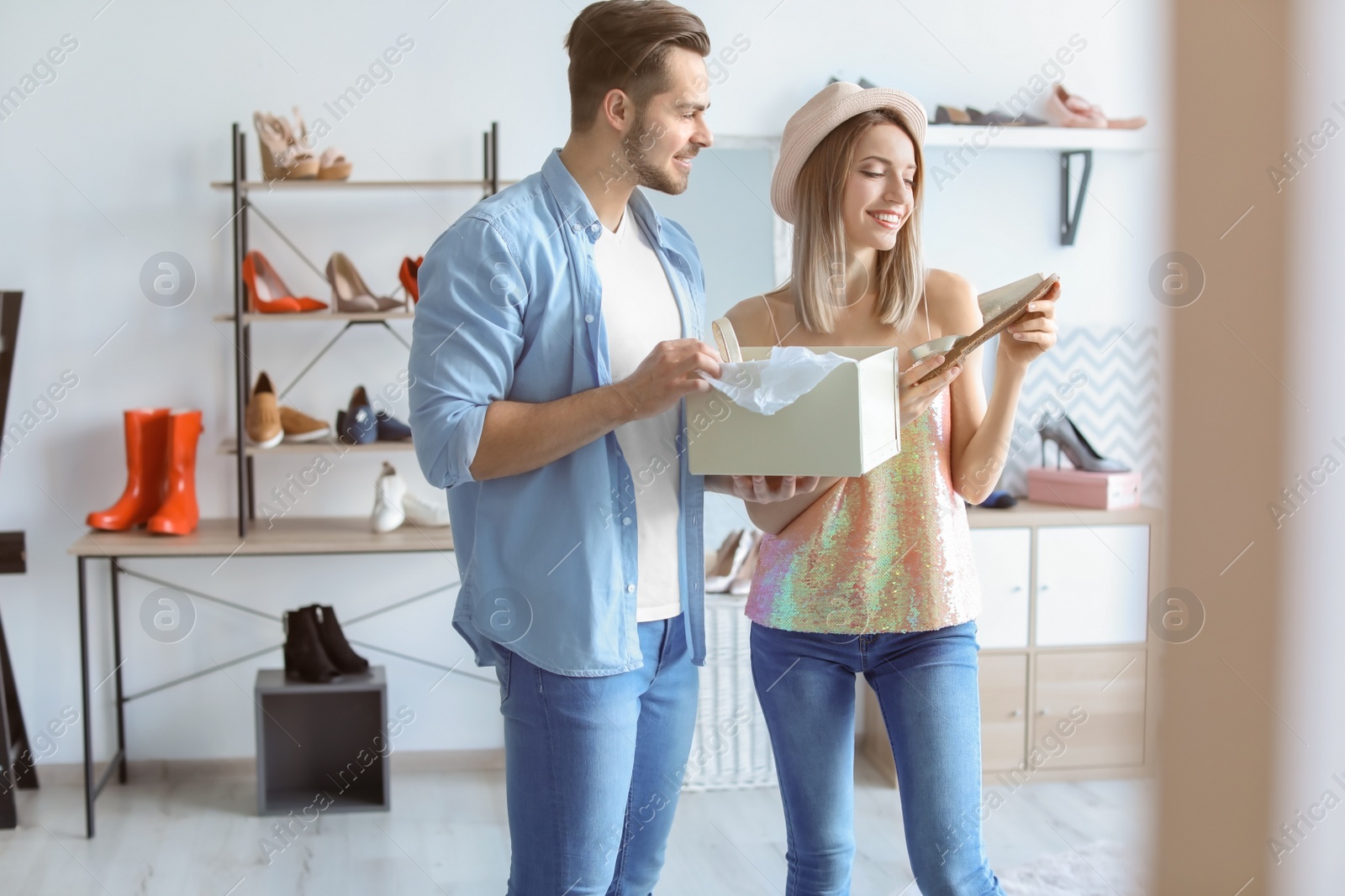 Photo of Young couple choosing shoes in store