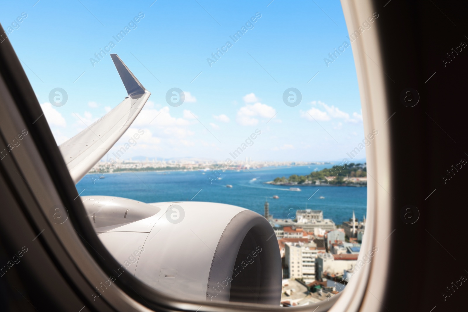 Image of Beautiful city and sea, view through airplane window during flight