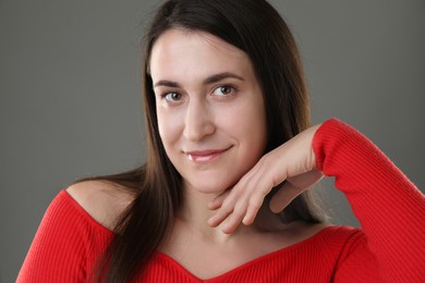 Portrait of beautiful young woman on grey background