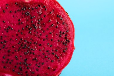 Photo of Delicious cut red pitahaya fruit on light blue background, closeup