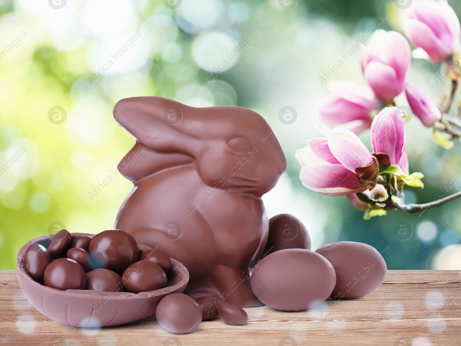 Image of Sweet chocolate bunny and eggs on wooden table outdoors. Easter celebration