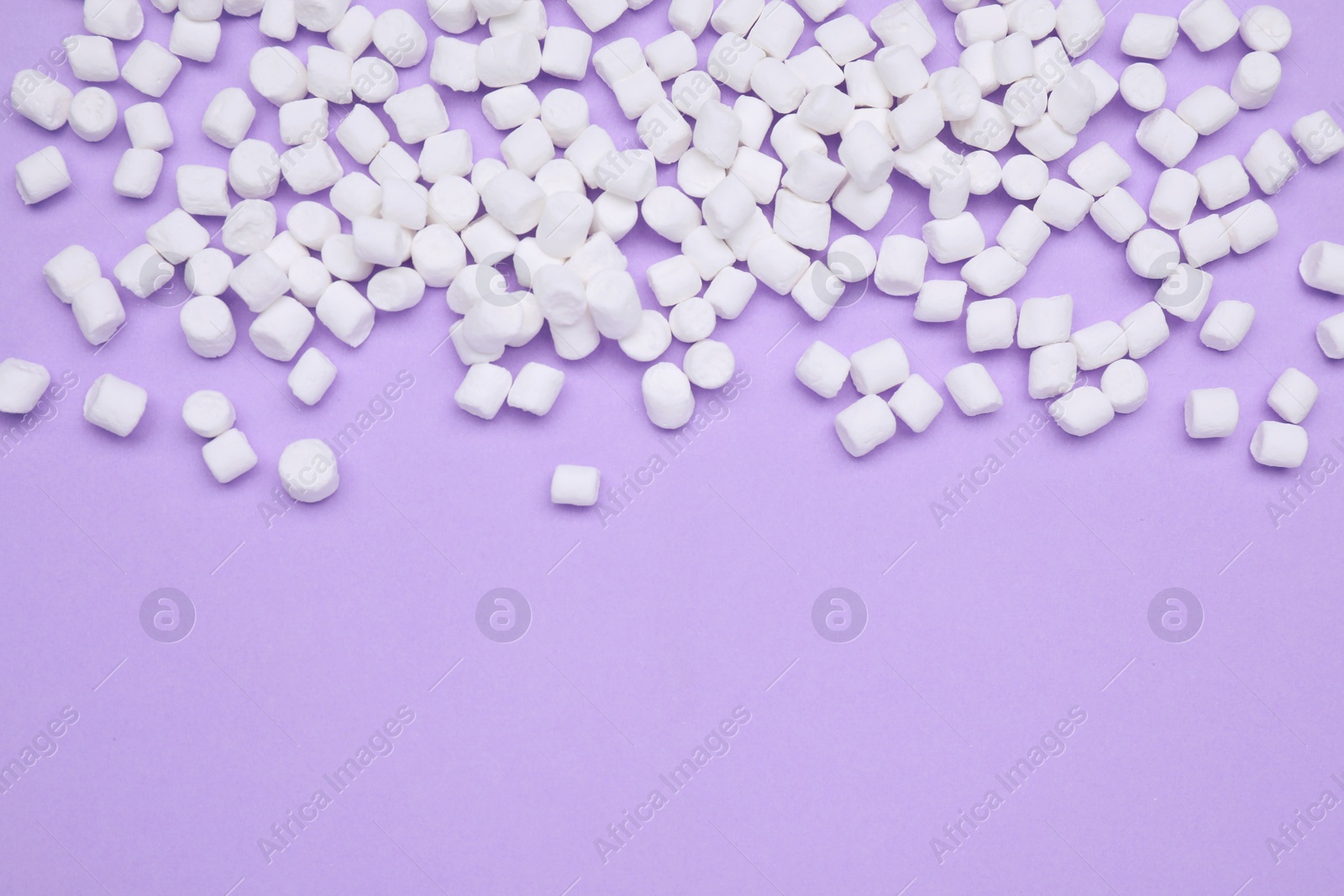 Photo of Delicious sweet marshmallows on purple background, flat lay. Space for text