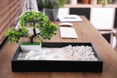 Beautiful miniature zen garden and computer on wooden table in office