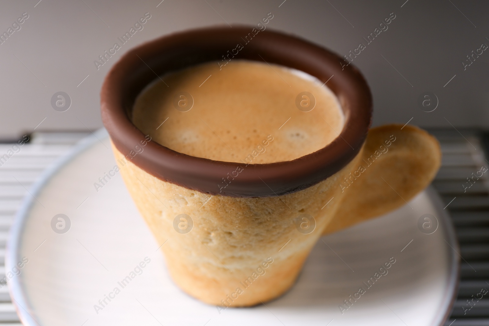 Photo of Delicious biscuit cup with espresso on grey background, closeup