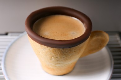 Delicious biscuit cup with espresso on grey background, closeup