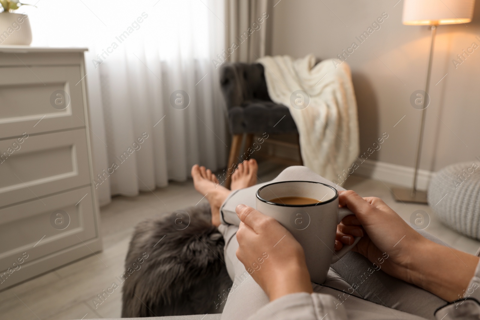 Photo of Woman with cup of hot drink resting at home, closeup. Space for text