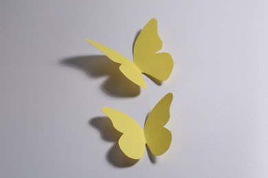 Photo of Two yellow paper butterflies on light background