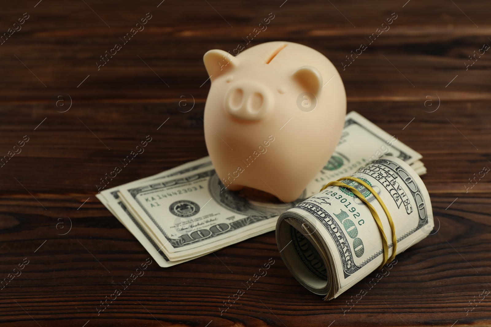 Photo of Money exchange. Dollar banknotes and piggy bank on wooden background