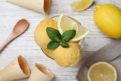 Yummy lemon ice cream served on white wooden table, flat lay