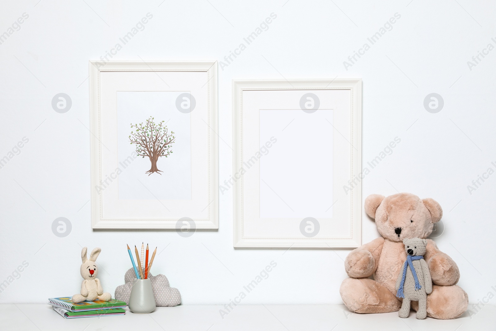 Photo of Composition with soft toys and photo frame on white background. Child room interior decor