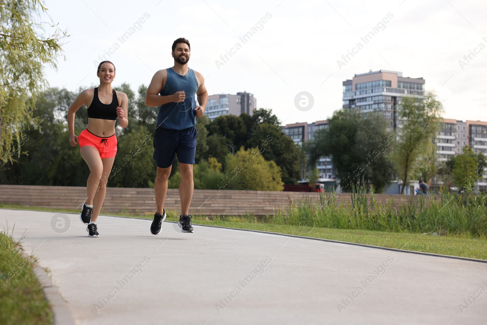 Photo of Healthy lifestyle. Happy couple running outdoors, space for text