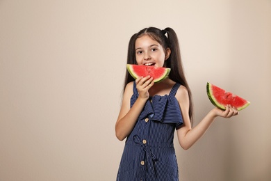 Photo of Cute little girl with watermelon on beige background. Space for text