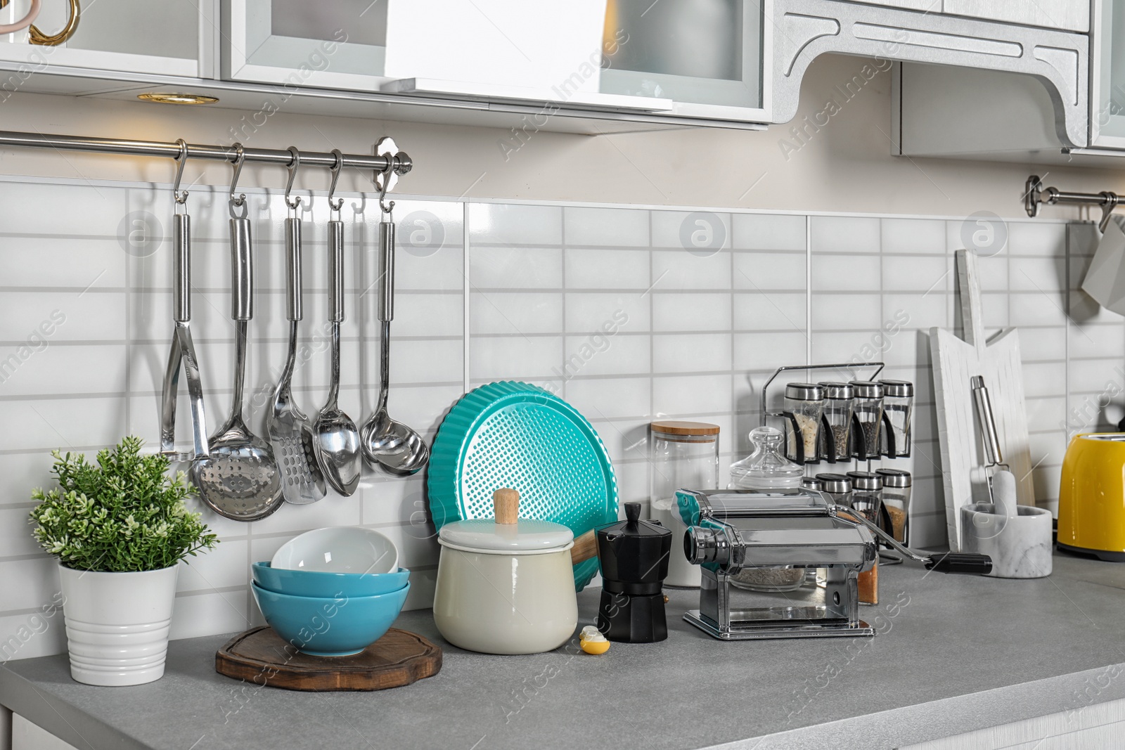 Photo of Set of cookware, clean dishes and accessories on kitchen counter