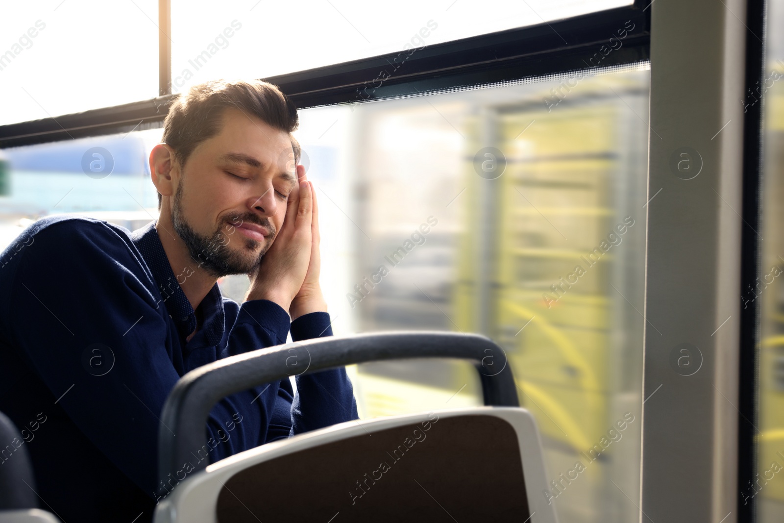 Photo of Tired man sleeping while sitting in public transport