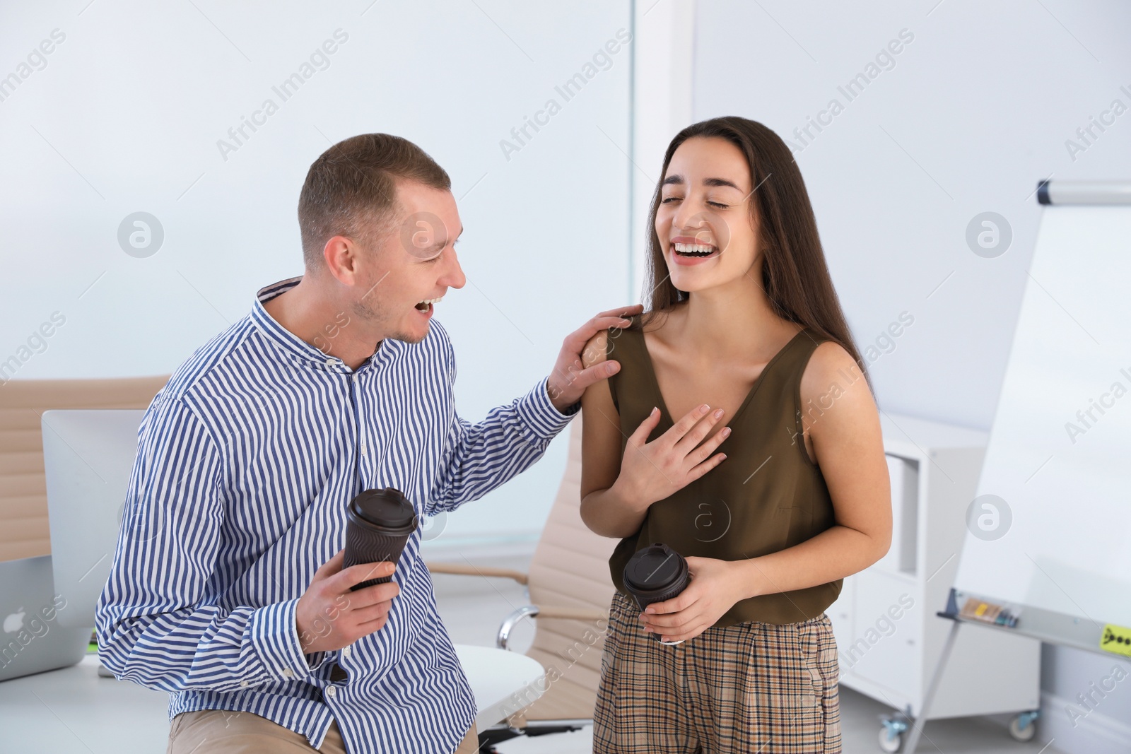 Photo of Office employees laughing together at workplace