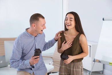 Photo of Office employees laughing together at workplace