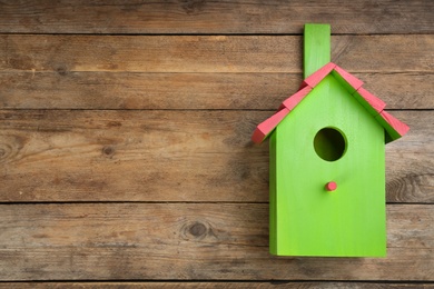 Beautiful green bird house on wooden background, space for text