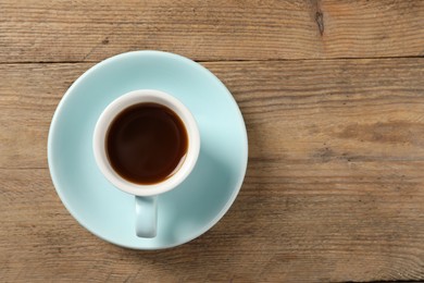 Tasty coffee in cup on wooden table, top view. Space for text