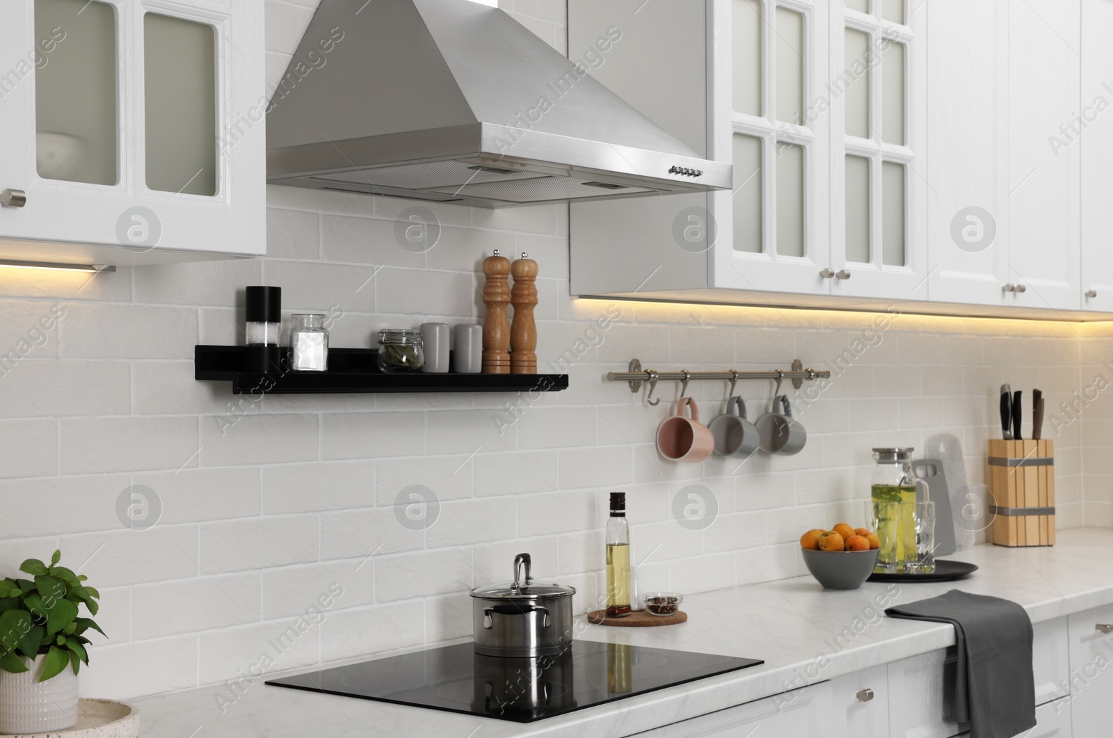 Photo of Modern range hood and furniture in kitchen