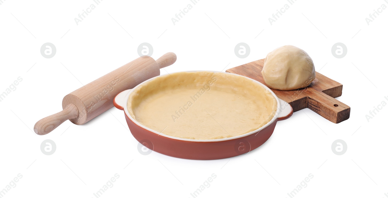 Photo of Pie tin with fresh dough and rolling pin isolated on white. Making quiche