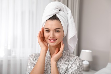 Photo of Beautiful young woman with hair wrapped in towel at home
