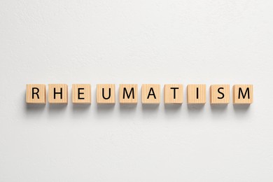 Photo of Word Rheumatism made of cubes on white background, top view