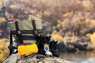 Photo of Set of camping equipment on rock outdoors. Space for text