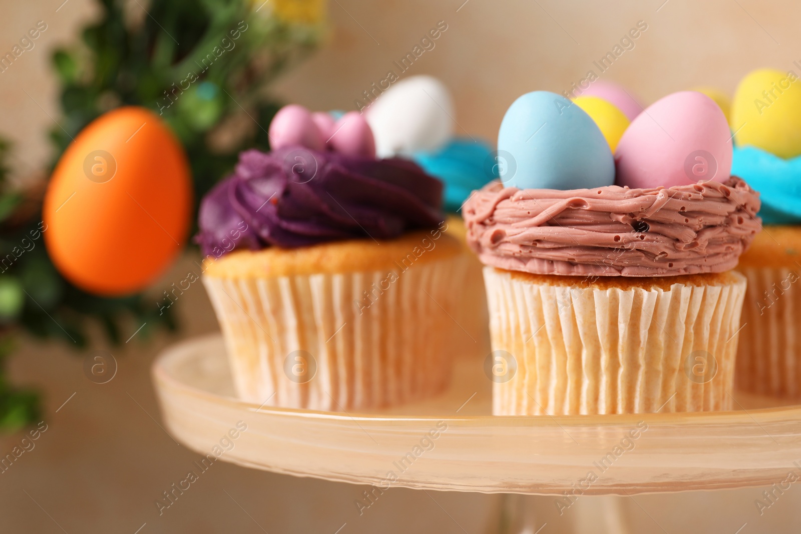 Photo of Tasty decorated Easter cupcakes on stand, closeup