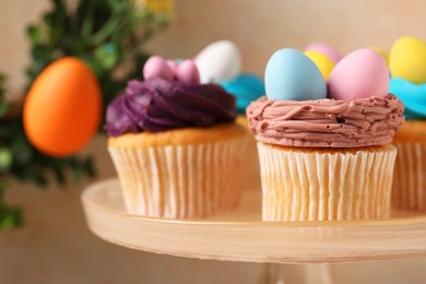 Tasty decorated Easter cupcakes on stand, closeup