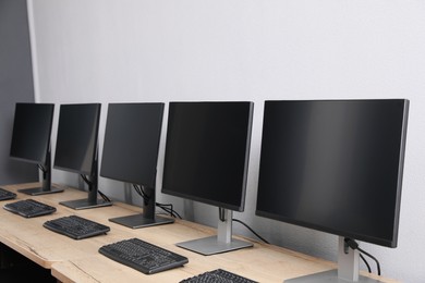 Photo of Open office interior. Modern workplaces with computers near light grey wall