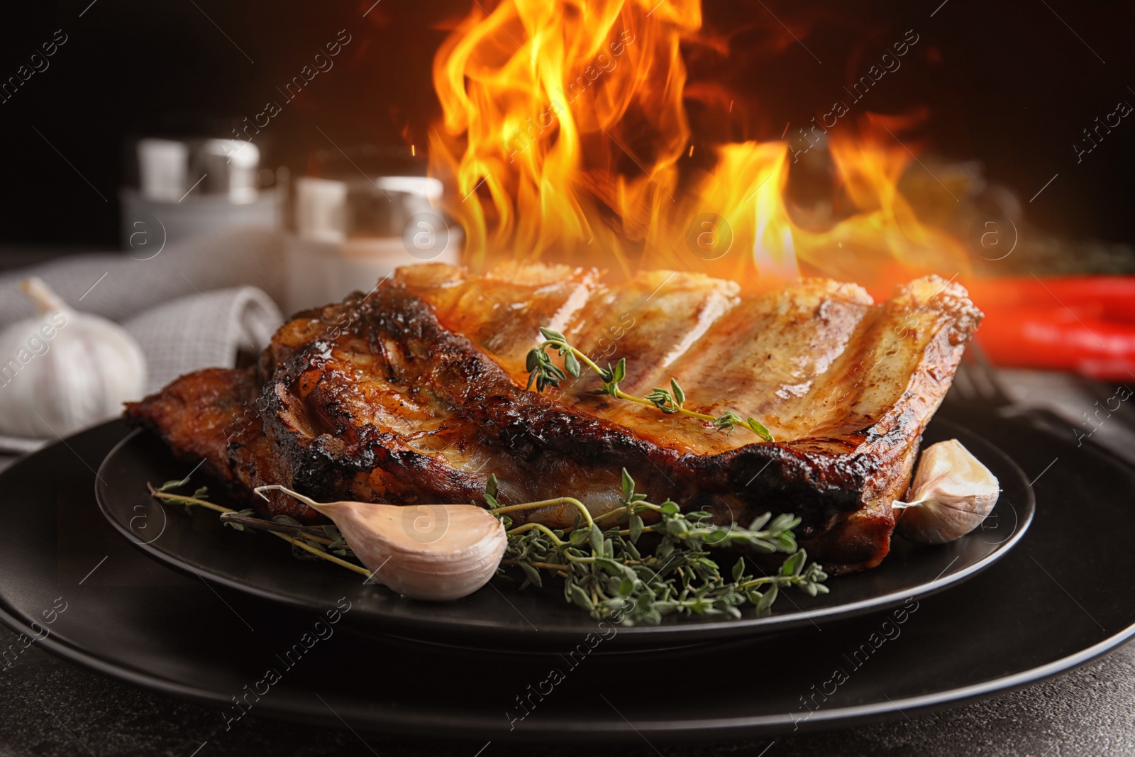 Image of Tasty grilled ribs with flame on plate