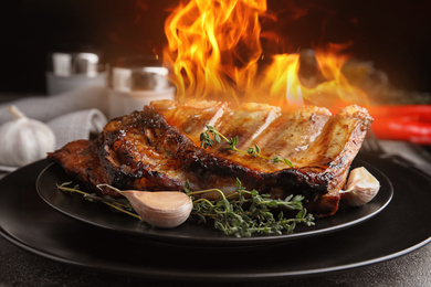 Image of Tasty grilled ribs with flame on plate