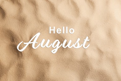 Image of Hello August. Beach sand as background, top view