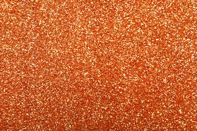 Image of Beautiful shiny orange glitter as background, closeup