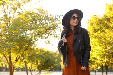 Photo of Beautiful young woman wearing stylish clothes in autumn park
