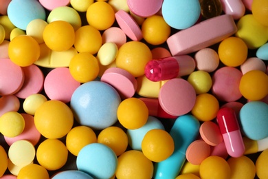 Heap of many different colorful pills as background