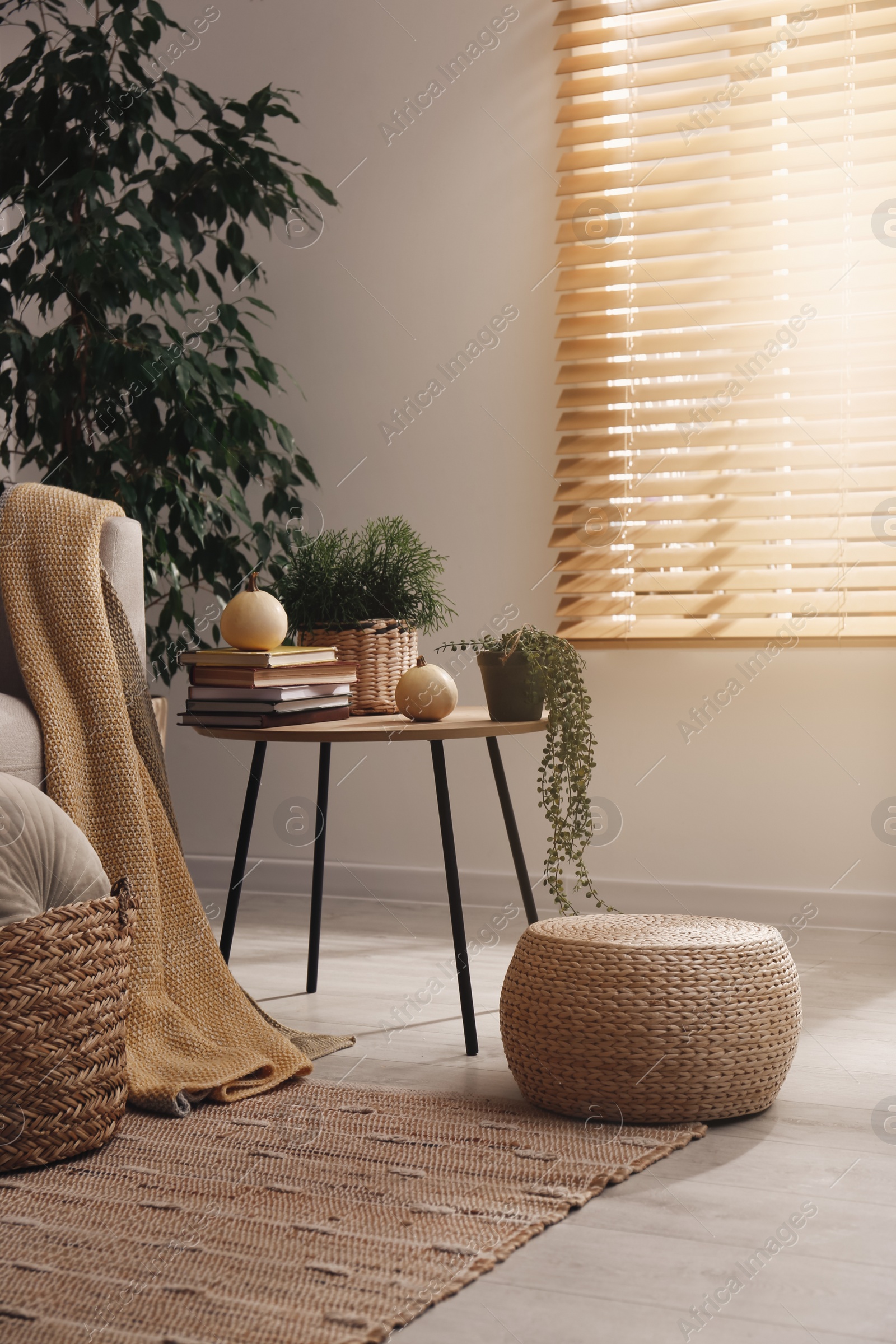 Photo of Stylish living room interior with table and wicker pouf