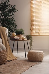 Stylish living room interior with table and wicker pouf