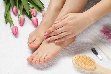 Photo of Woman with neat toenails after pedicure procedure on white terry towel, closeup
