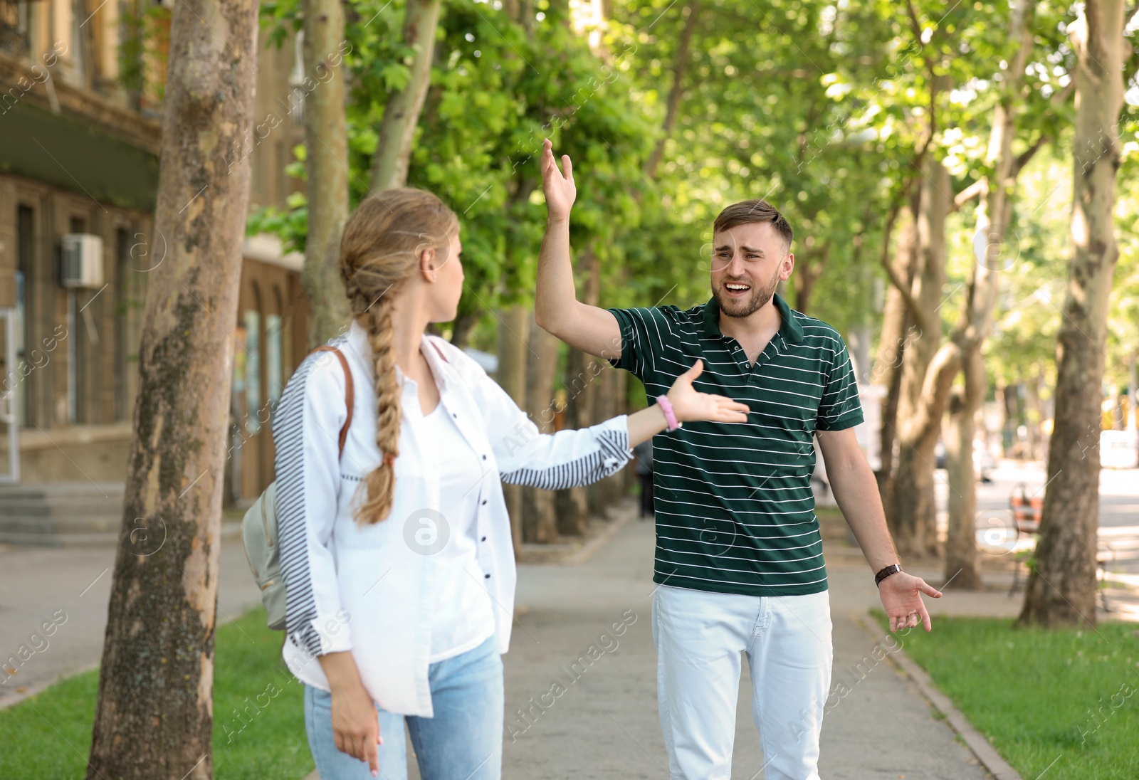 Photo of Young couple arguing on street. Problems in relationship