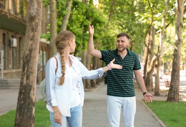 Photo of Young couple arguing on street. Problems in relationship