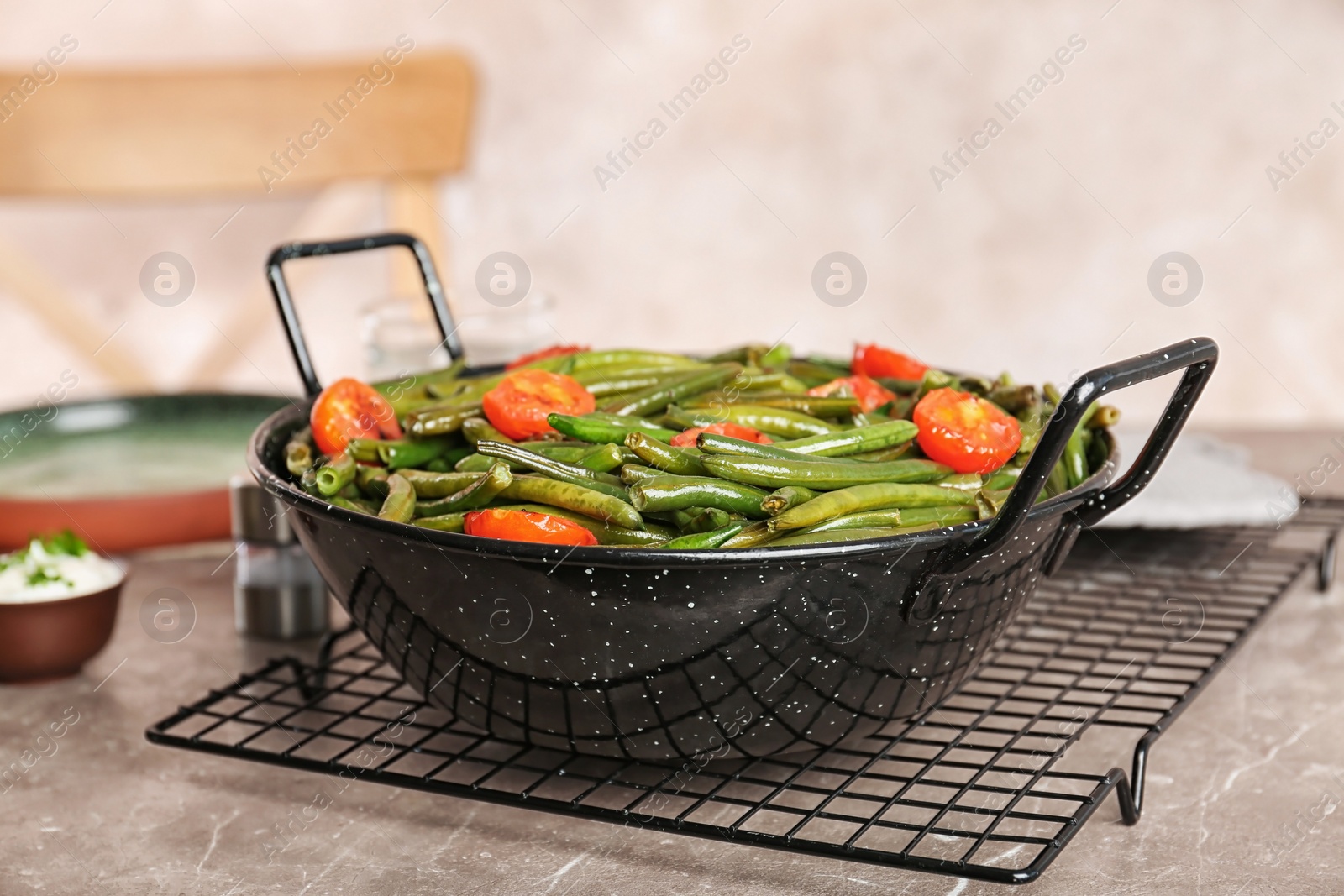 Photo of Tasty green beans with cherry tomatoes in serving pan on table