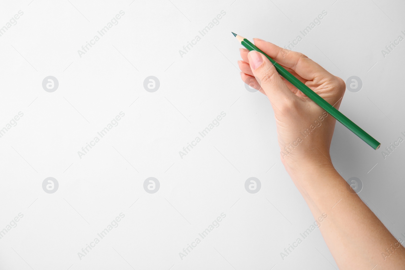 Photo of Woman with green pencil on white background, closeup. Space for text