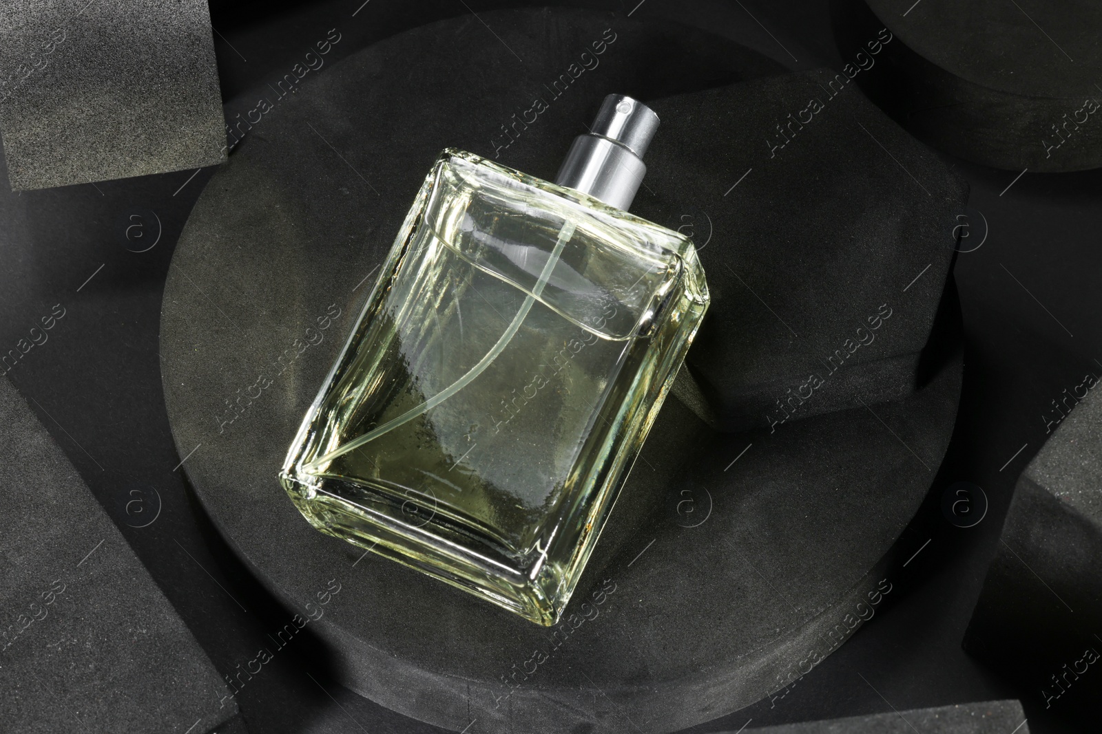 Photo of Stylish presentation of luxury men`s perfume in bottle on black background, above view