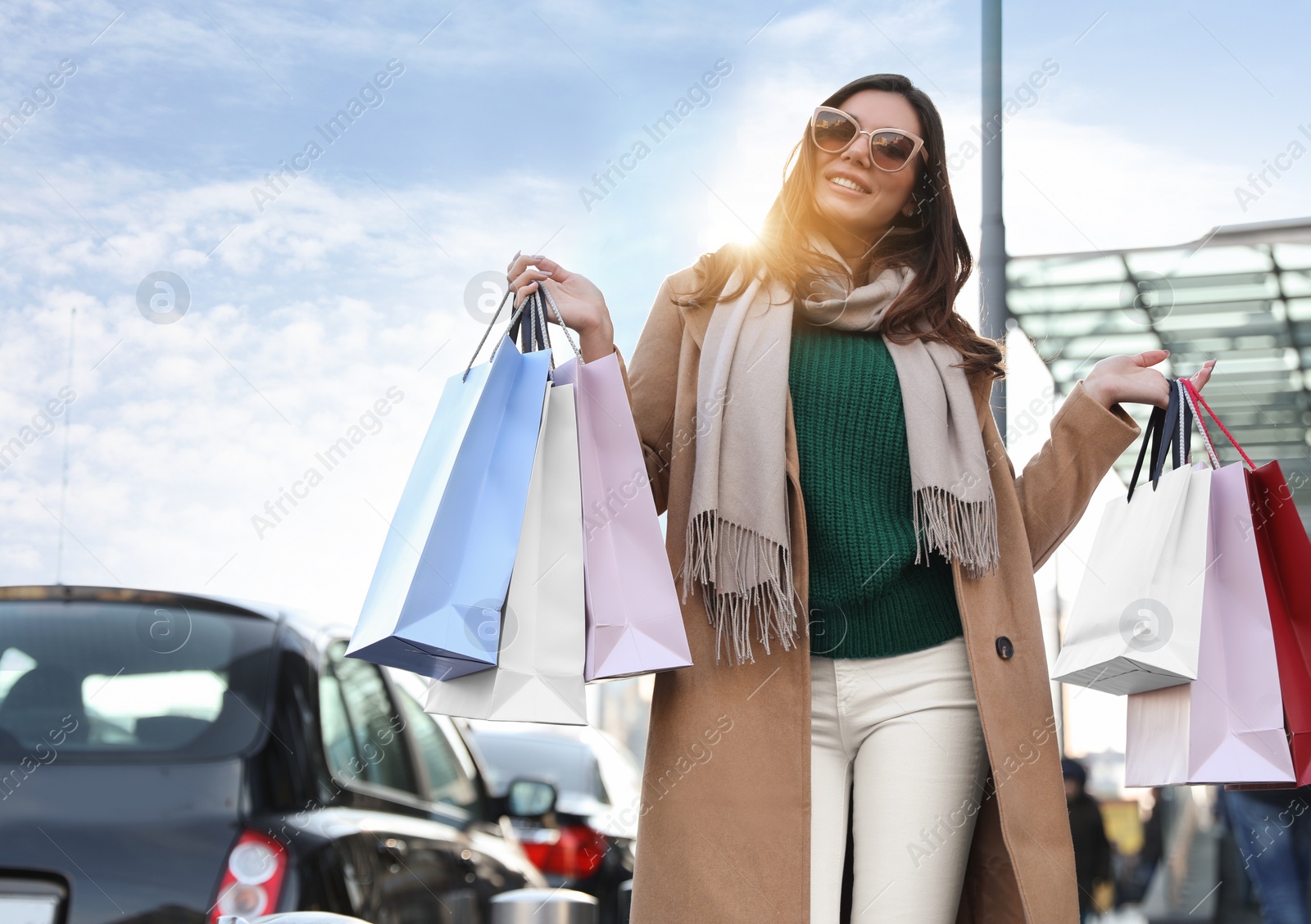 Photo of Beautiful young woman with shopping bags on city street