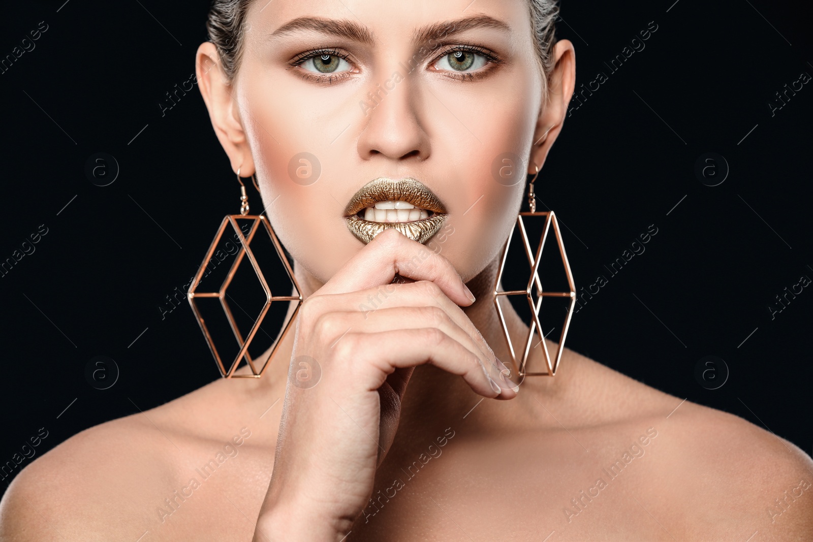 Photo of Portrait of beautiful lady with gold lipstick on black background, closeup